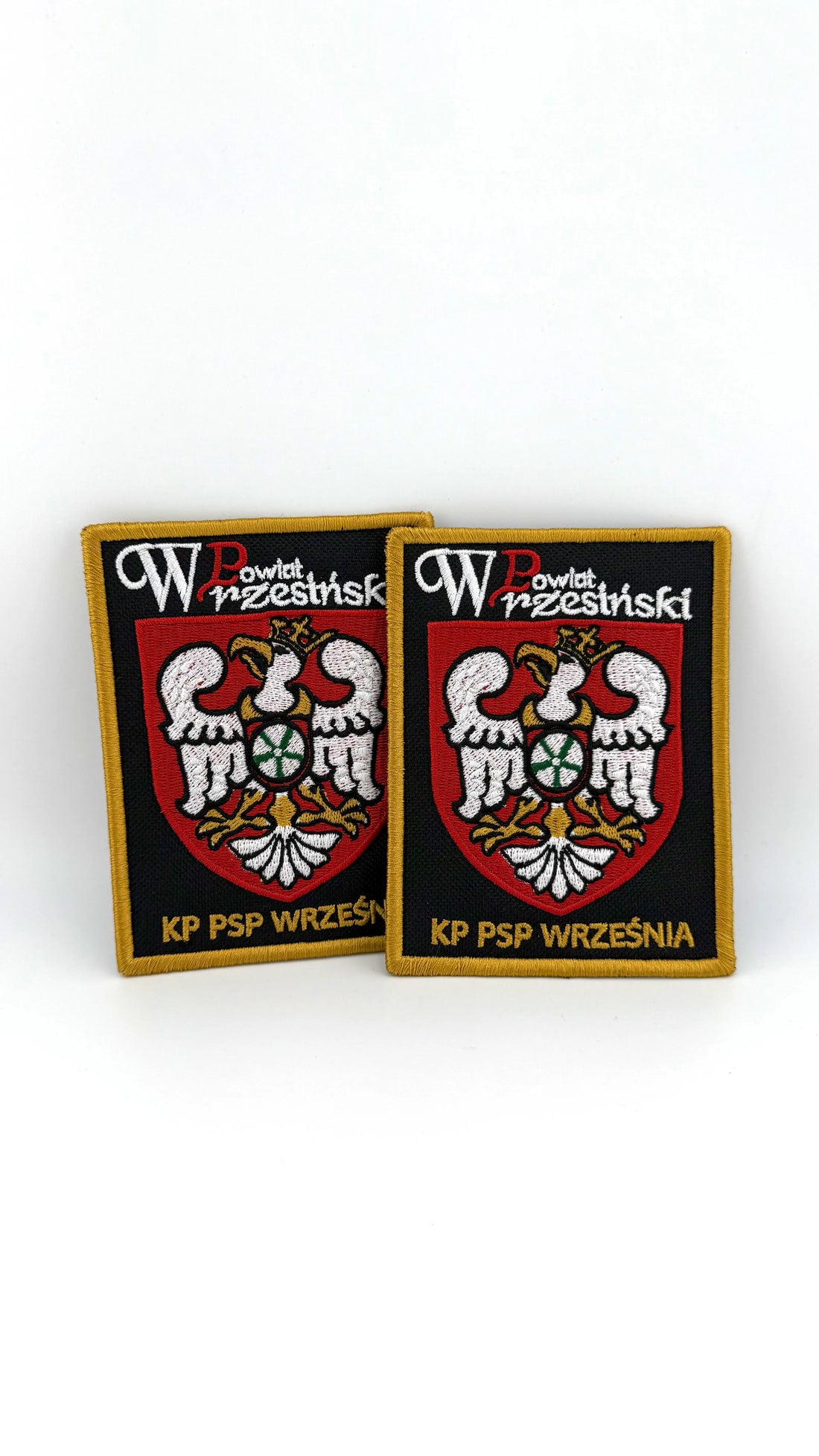 Dwie haftowane naszywki z rzepem z herbem Powiatu Wrzesińskiego i napisem KP PSP WRZEŚNIA - czarne tło, złote obszycie