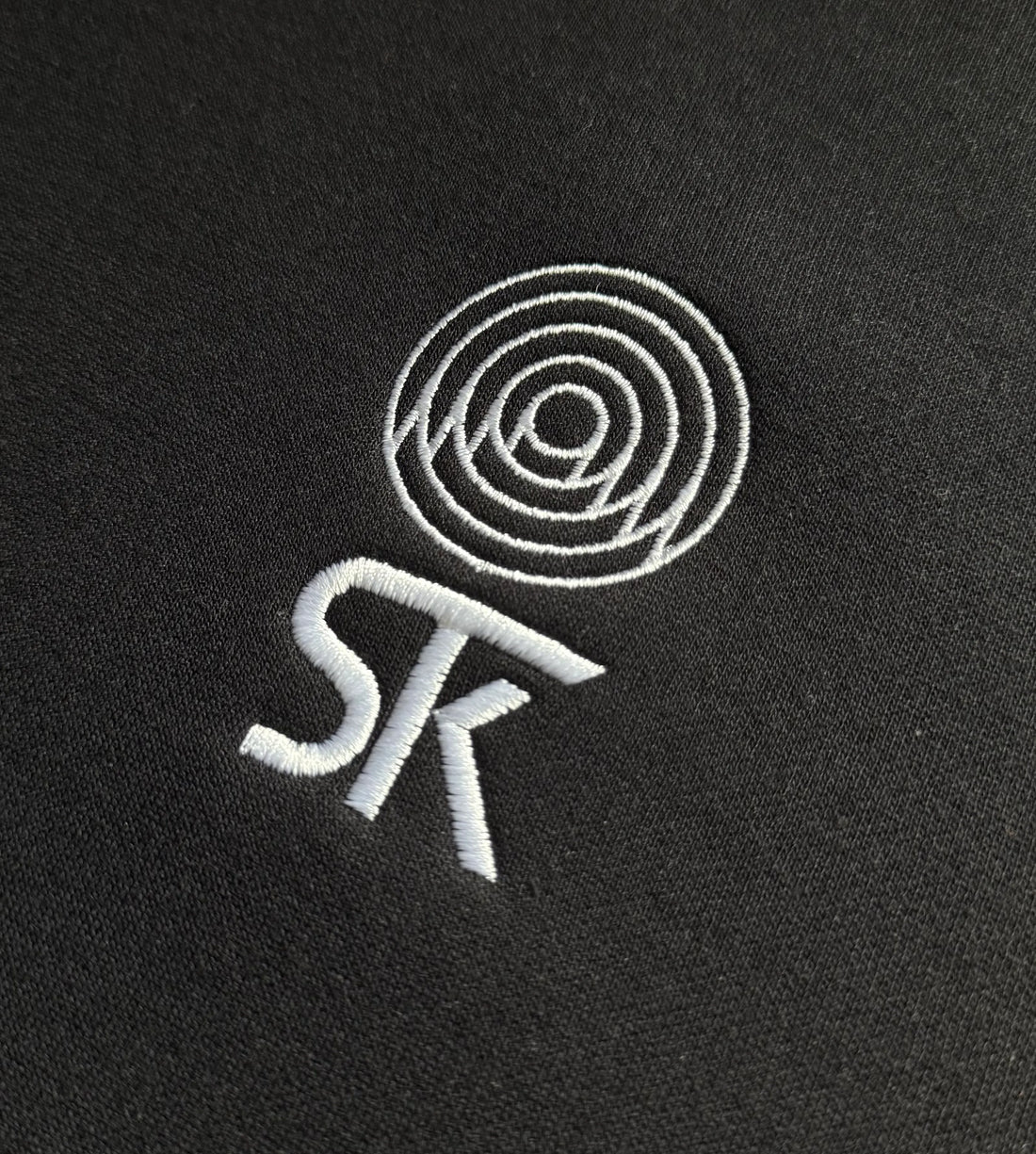 minimalistyczny haft logo na czarnej bluzie 