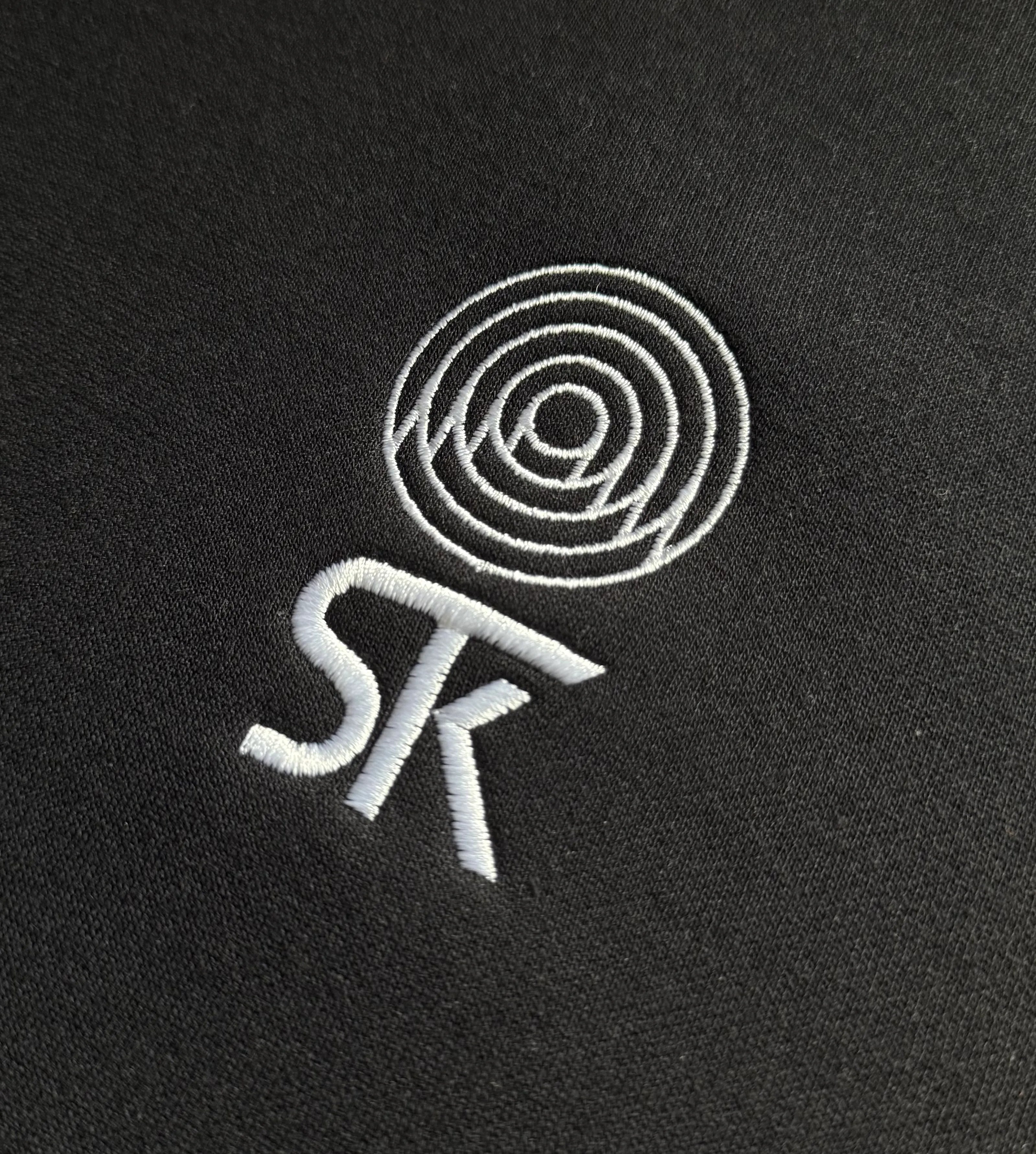 minimalistyczny haft logo na czarnej bluzie 